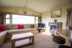 亨斯坦顿Lovely 8 Berth Caravan At A Brilliant Holiday Park, Manor Park Ref 23023t的带沙发和电视的客厅