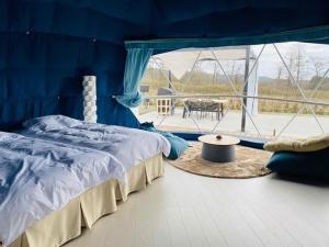 藏王chillout glamping zao的蓝色的客房配有一张床和一张桌子