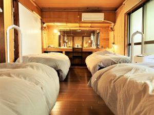 濑户内町奄美ゲストハウス HUB a nice INN的一间设有三张床和水槽的客房