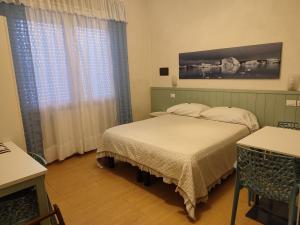 蒂勒尼亚欧罗酒店的一间卧室配有两张床和一张桌子及椅子