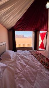 瓦迪拉姆Wadi Rum Sunset Camp的一间卧室设有一张大床和大窗户