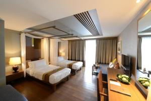 清迈拉林金达温泉度假酒店的酒店客房配有两张床和一张书桌