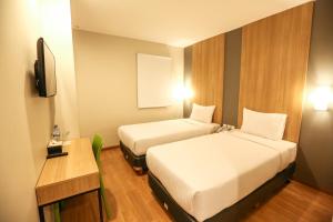 日惹Hotel Citradream Tugu Yogyakarta的酒店客房设有两张床和电视。