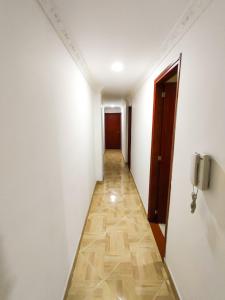 麦德林Apartamento en Laureles con Excelente Ubicación的走廊设有白色墙壁和瓷砖地板
