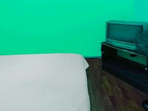 名古屋SPOT ON 92538 Joyoakis Homestay Syariah的一间卧室配有一张床和电视