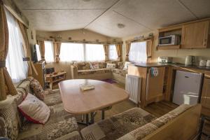 亨斯坦顿Caravan With Decking At Manor Park In Hunstanton, Sleeps 6 Ref 23045b的客厅设有厨房和大篷车内的桌子
