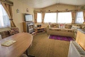 亨斯坦顿Caravan With Decking At Manor Park In Hunstanton, Sleeps 6 Ref 23045b的客厅配有桌子和沙发