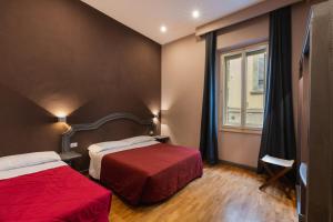 佛罗伦萨尤尼科莫酒店的酒店客房设有两张床和窗户。