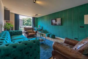 米德尔堡The Roosevelt Apartments的客厅设有蓝色的沙发和绿色的墙壁