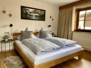 埃尔瓦尔德Haus Tirol Ehrwald的一间卧室配有一张带白色床单的床和一扇窗户。