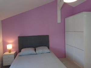 波尔多chambre privée à BORDEAUX PELLEGRIN的一间卧室设有紫色墙壁和一张床