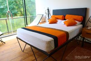 库鲁内格勒Kakulanda Resort的窗户间里一张带橙色枕头的床