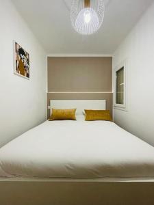 马赛Chez Antho T4 - appart T4 moderne en plein cœur du Panier的卧室内的一张白色大床,配有吊灯