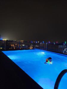 岑山Tuấn Đạt Luxury FLC Sầm Sơn的夜间在游泳池游泳的人