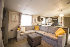 大雅茅斯Modern 6 Berth Caravan With Decking At Cherry Tree Park In Norfolk Ref 70324c的带沙发的客厅和厨房