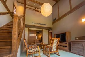 那须盐原市Shionoyu Onsen Rengetsu的一间带楼梯、椅子和电视的客厅