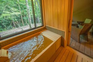那须盐原市Shionoyu Onsen Rengetsu的窗户房子里的热水浴缸