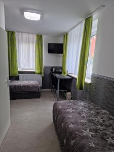 MühlauPension Valentina的一间卧室配有绿色窗帘、一张床和一张书桌
