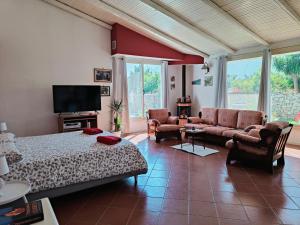 奇尼斯Villa Manzella piscina privata的一间卧室配有一张床、一张沙发和一台电视。