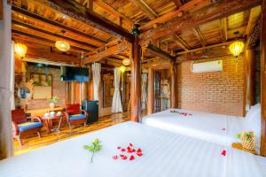 会安Eco Wooden villa Hoi An的一间卧室,床上有红色的鲜花