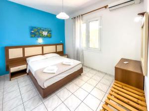 阿默达拉-伊拉克利翁Troulis Seaside的一间卧室设有一张床和蓝色的墙壁