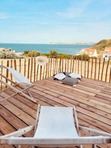 欧丹冈Villa vue exceptionnelle sur le Cap Gris-Nez的木甲板上配有两把椅子和椅子,享有海景