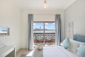 迪拜FAM Living - Sarai Apartments - Private Beachfront Escape in Palm Jumeirah的一间卧室设有一张床,享有阳台的景色
