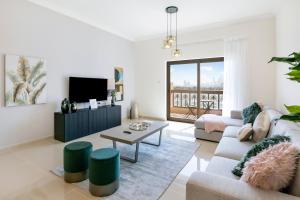 迪拜FAM Living - Sarai Apartments - Private Beachfront Escape in Palm Jumeirah的带沙发和电视的客厅