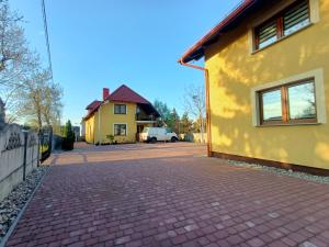 绿山城Noclegi Zielona Góra u Moni的黄色房子前面的砖路