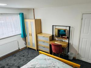 莱斯特CozyComfy Apartment Leicester的一间卧室配有书桌和镜子