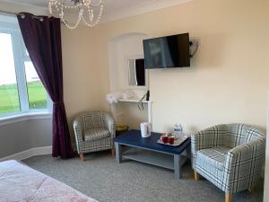 奈恩"Room only" at Wetherby Nairn的一间设有两把椅子、一张桌子和一台电视的房间