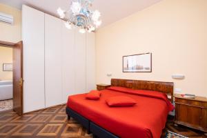威尼斯卡佛斯克罗公寓的一间卧室配有一张红色的床和吊灯。
