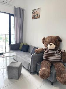 吉隆坡HomeFeel Netflix Youtube WiFi 5min drive to DesaPark的客厅里坐在椅子上的大泰迪熊