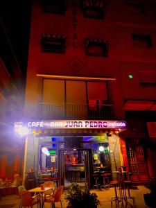 滨海罗克塔斯佩德罗胡安膳食公寓酒店的大楼前设有桌椅的餐厅