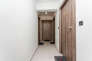 塞萨洛尼基John Central Suites的走廊设有木门,铺有瓷砖地板