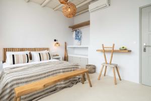 艾丽奇Cavos Paros Boho Chic sea-view apartment in Aliki的一间卧室配有一张床和一张木椅