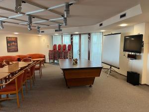 埃格尔艾斯特拉高级酒店的一间会议室,配有桌椅和白板