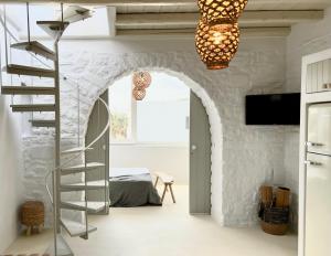 艾丽奇Cavos Paros Boho Chic sea-view apartment in Aliki的一间设有螺旋楼梯的房间和一间卧室