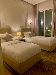 多哈Beachfront Luxury Apartment-The Home-Pearl Island的酒店客房,设有两张床和镜子