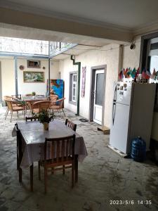 布哈拉Nur-Niso Guest House的客房内的厨房配有桌子和冰箱