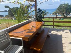 YialósHoumas Apartments的海滩庭院的木桌和长凳