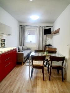 多尔尼莫拉瓦APARTMÁNY za SNĚŽNÍKEM的厨房以及带桌椅的起居室。
