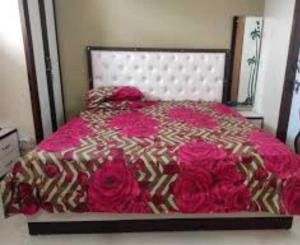 罗塔克OYO Home Safe In的一间卧室配有一张带粉红色床单和玫瑰的床。