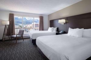 朱诺Ramada by Wyndham Juneau的酒店客房设有两张床和窗户。