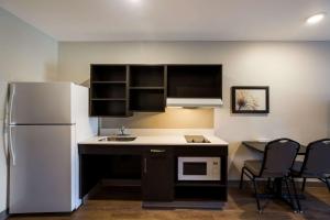 克莱蒙WoodSpring Suites Orlando West - Clermont的厨房配有冰箱和桌椅