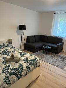 奥西耶克Apartment VBK Osijek的一间卧室配有一张床和一张黑色沙发