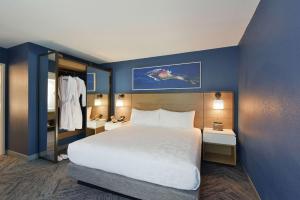 圣克拉拉广场套房酒店的酒店客房设有一张大床和蓝色的墙壁。