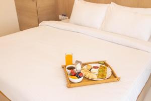 纳威孟买Pushp Vatika Resort & Lawns的床上的食品和饮料托盘