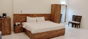 纳威孟买Pushp Vatika Resort & Lawns的一间卧室配有一张大床和木制床头板