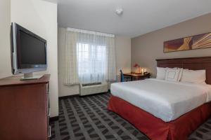 博伊西TownePlace Suites by Marriott Boise Downtown/University的配有一张床和一台平面电视的酒店客房